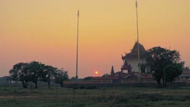 Mor renkli günbatımında kırsal arka planda Pagoda