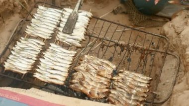 İn-yer Barbekü ızgara ve pişirme maşa kullanarak balık ile