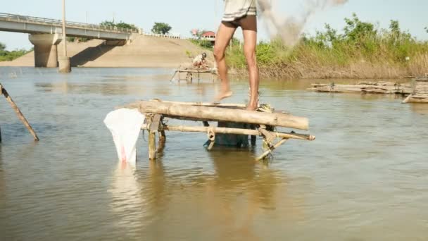 Рыбак бросает сеть в пруд с небольшой бамбуковой платформы (крупным планом ) — стоковое видео