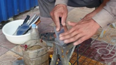 Kaldırımda bir bıçak whetting ve bıçak kontrol etmek için parmağını çalışan bıçak kalemtıraş üzerinde Kapat