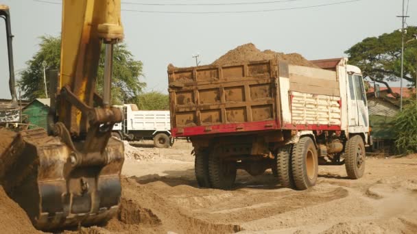 Excavadora cargando arena en un camión pequeño — Vídeo de stock