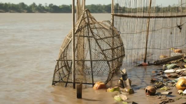 Παγίδα χειροποίητα ψάρι φτιαγμένο από μπαμπού που σε ρηχά νερά από το riverside σε μια θυελλώδη ημέρα — Αρχείο Βίντεο