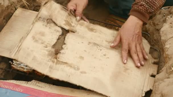 妇女在地面烤肉覆盖与纸板 (关闭 ) — 图库视频影像