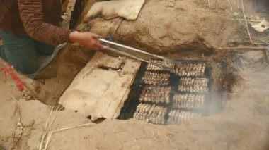 İn-yer Barbekü ızgara ve pişirme maşa kullanarak balık (yakın )
