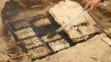 İn-yer Barbekü ızgara ve pişirme maşa kullanarak balık (yakın )