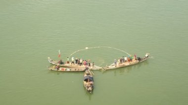 Fisher küçük teknelerde bir net balık nehirden çekerek
