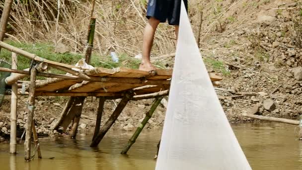 Perto de um pescador puxando a rede segurando peixes para si mesmo e fora da água — Vídeo de Stock