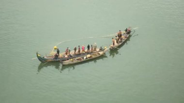Fisher küçük teknelerde bir net balık nehirden çekerek