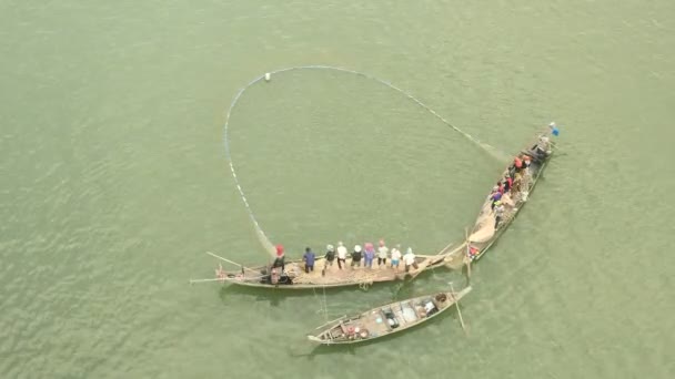 Рибалка в невеликих човнах витягує велику сітку риби з річки — стокове відео