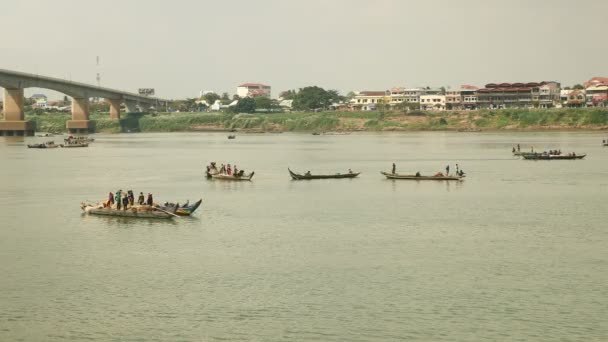 Pêcheurs dans des bateaux soulevant un grand filet hors de l'eau ; ville riveraine en arrière-plan — Video