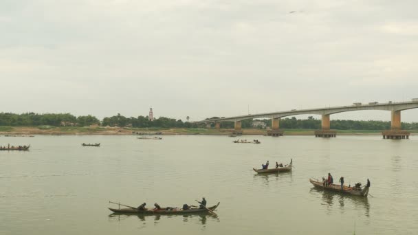 Fiskare i båtar som lyft ett stort netto ur vattnet. Bro över floden som bakgrund — Stockvideo