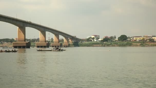 Fischer in Booten heben ein großes Netz aus dem Wasser. Brücke über Fluss als Kulisse — Stockvideo