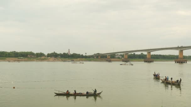 Fishers in boats lifting a large net out of water. Bridge over river as backdrop — Stock Video