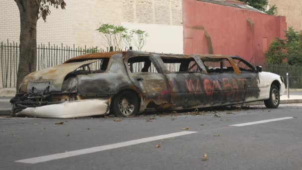 Vista lateral de una limusina blanca quemada en París — Vídeo de stock