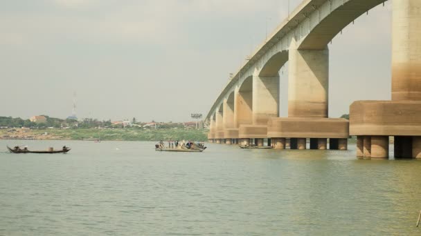 Рыбаки в лодках поднимают большую сеть из воды под мостом — стоковое видео