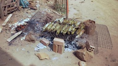 Açık bir ateş ve eğreti barbekü üzerinde ızgara muz pirinç kek
