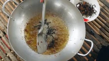 Ölü zehirli örümcekler yemek pişirmek için yağ kaynar içine dalan kadın 
