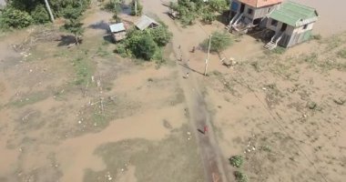 Kırsal bir köyde sel sularında yüzen insanların hava görüntüsü..