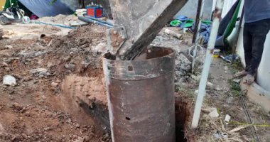 İnşaat alanında büyük bir metal yığını yönlendiren bir kazıcı kovasını kapatın..