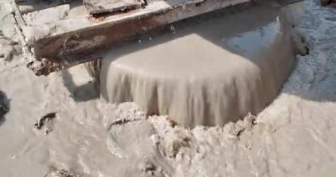 Metal bir zıpzıp içine dökülen taze betonu kapatmak, inşaat alanında çamurlu çamurun taşmasına neden olur..