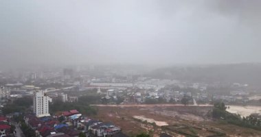 Yoğun sis ve sağanak yağmur altında Sihanoukville 'in kasvetli şehir manzarasından uzaklaşın.