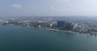 Geniş Sihanoukville kıyı manzarası, helikopter pistli modern iskele, kumlu sahil ve şehrin ufuk çizgisi..