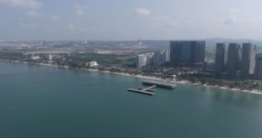 Sihanoukville kıyı manzarası, helikopter pistli modern iskele ve şehrin ufuk çizgisi..