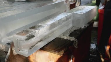Önceden kesilmiş küçük buz blokları bir kanca kullanarak bir dondurucuya koyarak buz satıcı