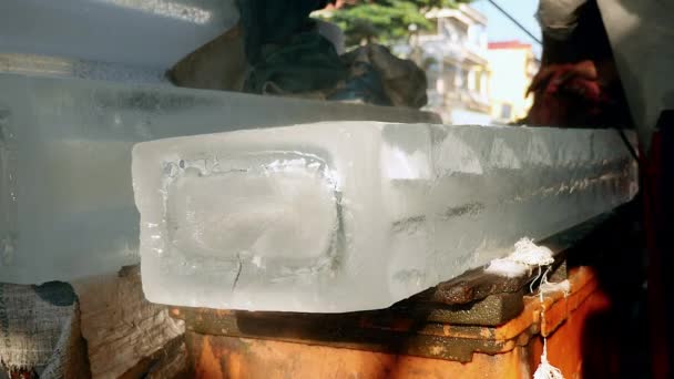 Vendeur de glace pré-découpe de petits blocs de glace dans un plus grand avec scie circulaire — Video