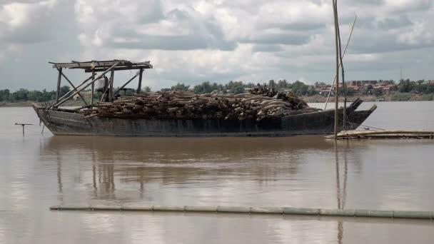 Bambu stolpar som plankans över en stillastående pråm på en flod under mulen himmel — Stockvideo