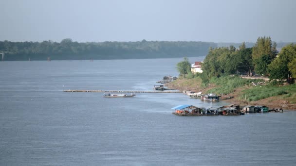 Houseboats sul lungofiume con un traghetto che attraversa il fiume e raggiunge il molo — Video Stock