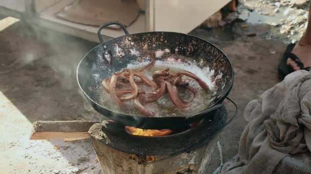 Agitar serpientes fritas dentro de un wok usando unas pinzas metálicas — Vídeos de Stock