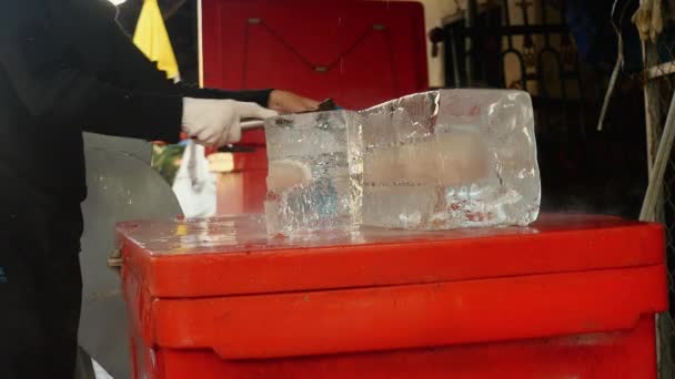 Παγετώνων πωλητής κοπή μικρών μπλοκ του πάγου με το τσεκούρι του και τη διατήρησή του σε πλαστικές σακούλες — Αρχείο Βίντεο