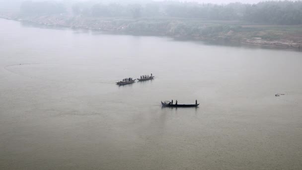 Upper view of a group of fishers in small fishing boats pulling a large net out of river in fog — Stock Video