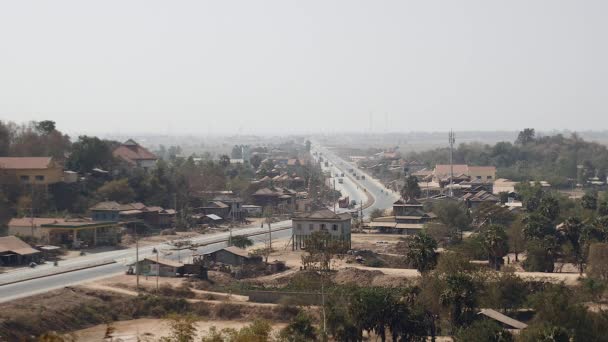 Vista a distancia de la carretera principal que pasa por una pequeña ciudad bajo cielos despejados — Vídeos de Stock