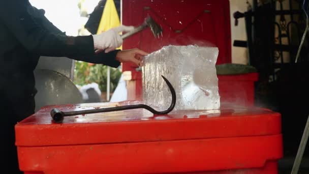 Ice seller cutting small blocks of ice with his hatchet — Stock Video