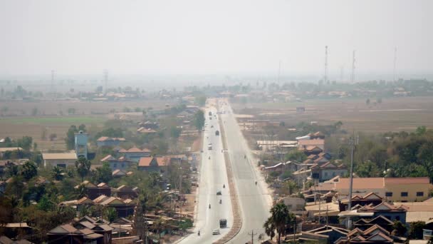 Vista superior de la carretera principal que pasa por una pequeña ciudad bajo cielos grises polvorientos (lapso de tiempo  ) — Vídeos de Stock