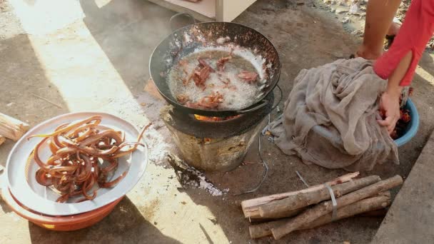 Frau taucht tote Frösche zum Kochen in kochendes Öl — Stockvideo