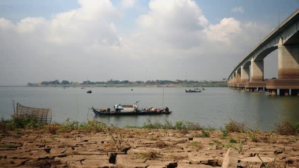 Małe drewniane rybackie łodzie w pobliżu mostu na rzece pod zachmurzonego nieba — Wideo stockowe
