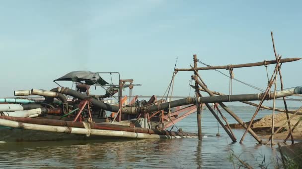 Barco de dragado junto a la orilla del río con sistema de tuberías sostener con postes de bambú para descargar la arena del río dragado — Vídeos de Stock