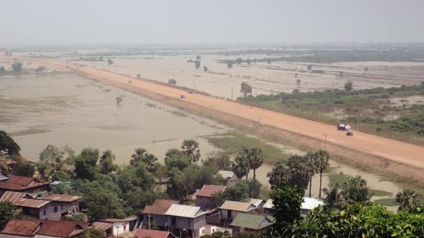 Vistas superiores de distância na estrada empoeirada através de campos de arrozais inundados — Vídeo de Stock