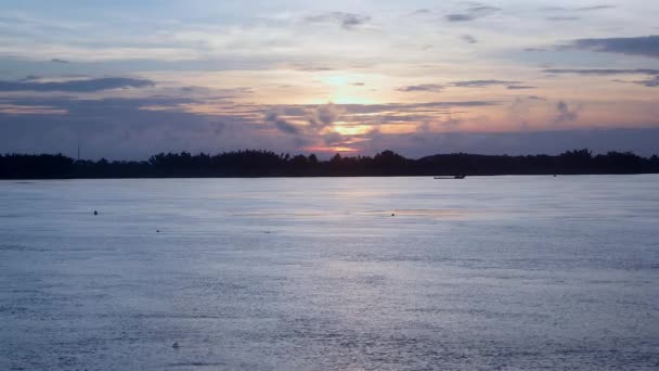 Lumière du coucher du soleil avec nuages épars sur la rivière. Bateau de pêche descendant la rivière comme toile de fond — Video