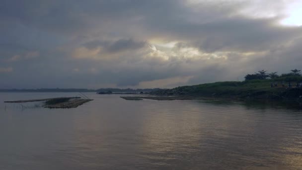 Lever de soleil nuageux foncé sur la rivière (prise d'un bateau atteignant le bord de la rivière )
