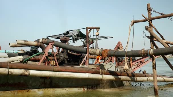 Barco de dragagem na margem do rio com sistema de dutos segure com postes de bambu para descarregar areia de rio dragada — Vídeo de Stock