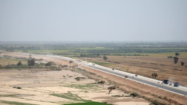 Vue de distance sur route pavée poussiéreuse avec circulation . — Video