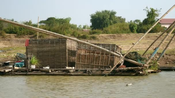 Large bamboo fish crates connected to a chinese fishing net at the river's edge — Stock Video