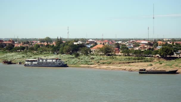 Ponte vista para a cidade ribeirinha com navio de cruzeiro e barca de rio ao longo da margem do rio — Vídeo de Stock