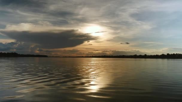 Вид з маленького моторного човна під час поїздки на озеро під шаром хмар на заході сонця — стокове відео