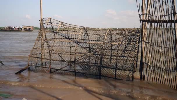 Primer plano de una gran trampa de bambú en el borde del río — Vídeo de stock