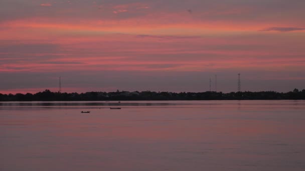 Маленькі рибальські човни силует на річці в фіолетових і рожевих відтінках світанку — стокове відео